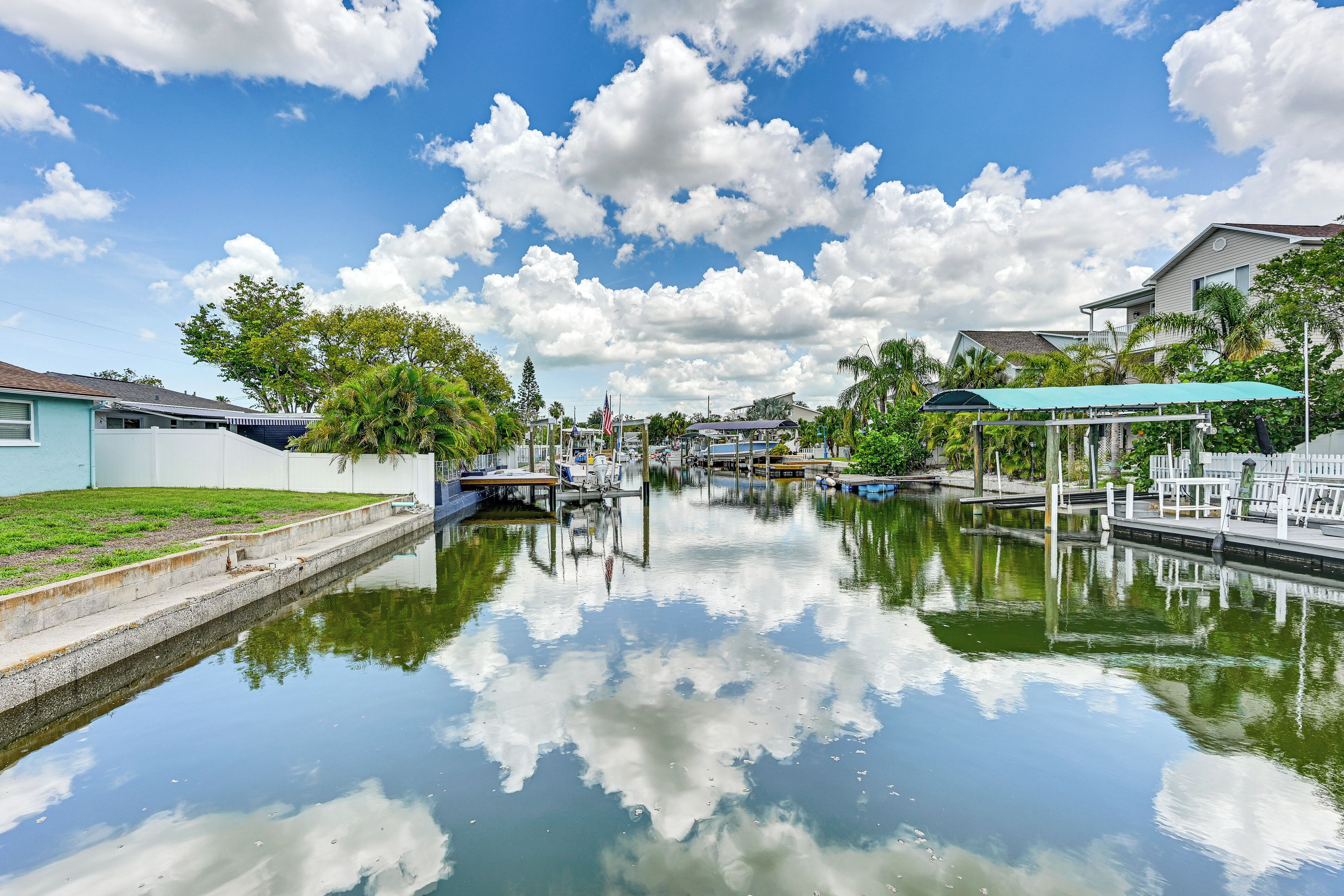 A calm waterway with boats, docks, and houses along the banks.