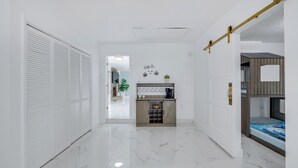 A hallway with a white door, a small kitchenette, and a bunk bed. - Swim, Hike & Kayak: Crystal River Retreat w/ Yard! (Crystal River)