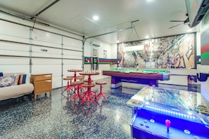 A billiards room with a pool table, stools, and a mural on the wall. - Waterfront Stonehaven at Reed Point w/ Swim Spa! (Grove)