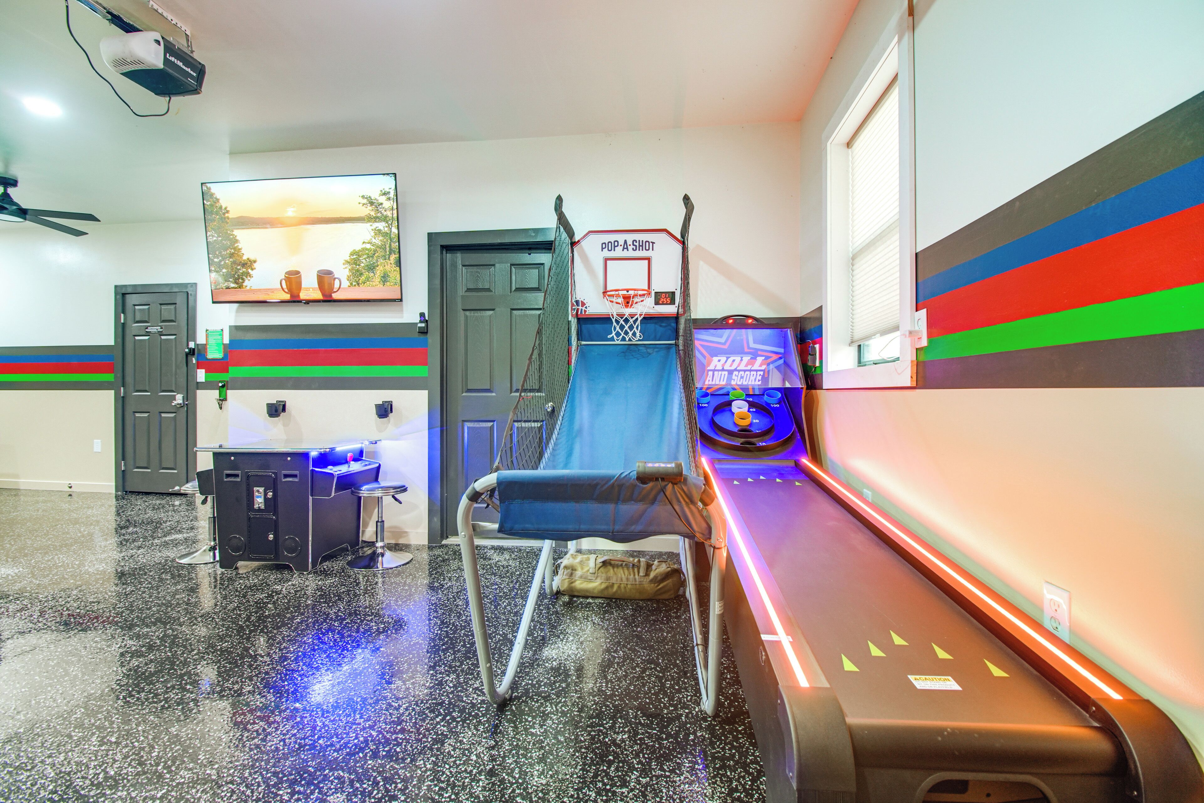 Una habitación con aro de baloncesto, cinta de correr y televisión montada en la pared.
