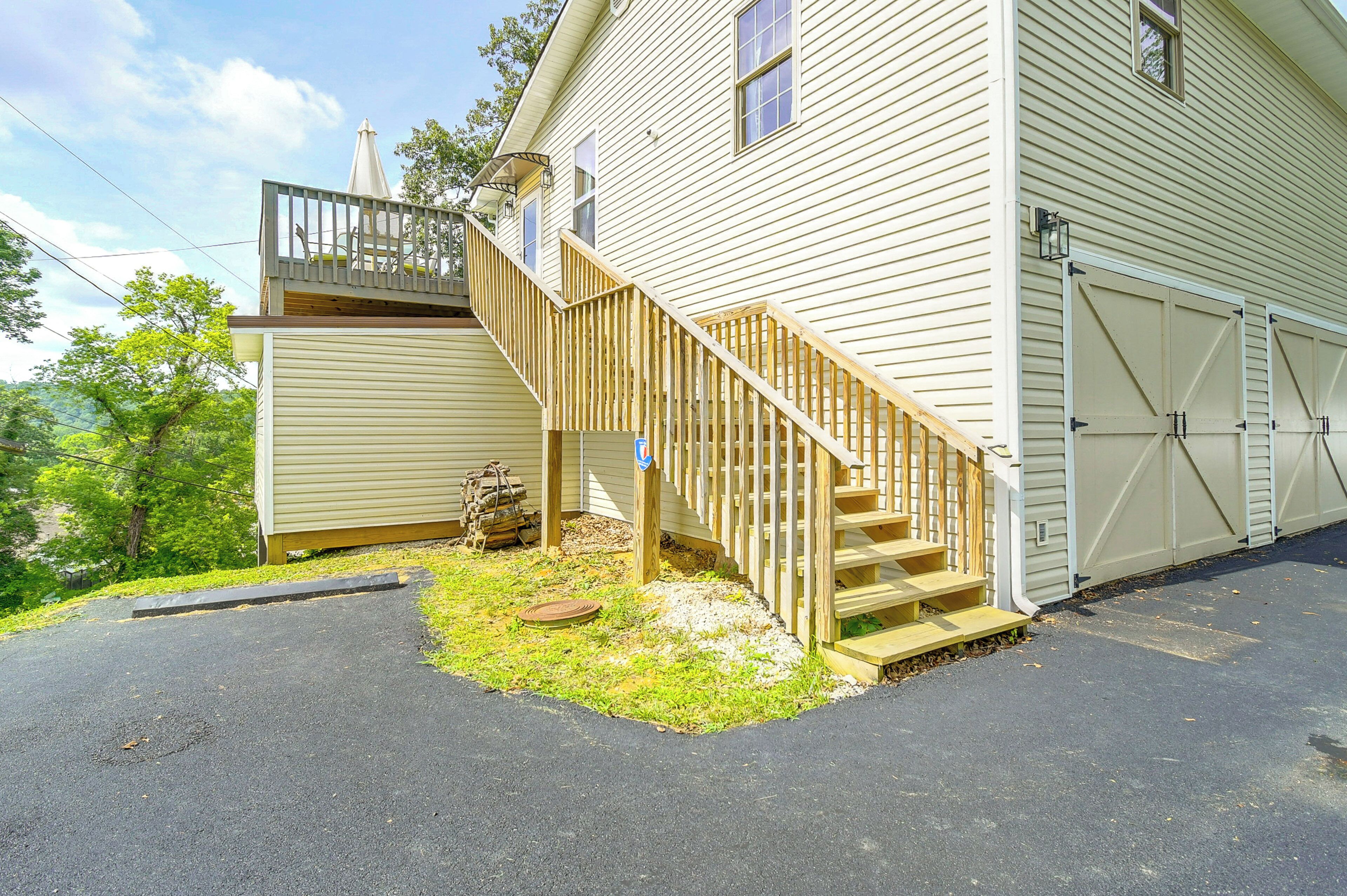 A two-story house with a wooden staircase, a garage, and a small deck.