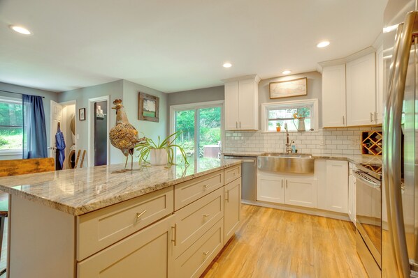 A modern kitchen with white cabinets, a marble countertop, and a stainless steel refrigerator. - Walk to Putnam Lake: Updated Home w/ Deck (Patterson)