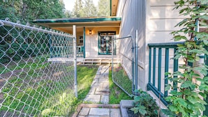 A house with a porch, a pathway leading to the entrance, and a chain-link fence. - Family Retreat 2 Mi to Santa's House: Pets Welcome (North Pole)