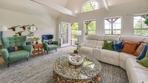 A spacious living room with a high ceiling, a large glass coffee table, a beige sectional sofa, and a green armchair. - Pool, Lake Views, Dock & More: Mt Vernon Getaway (Mount Vernon)