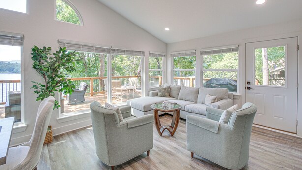 A spacious living room with a large window, a sofa, two armchairs, and a coffee table. - Lake Hamilton Views: Hot Springs Family Home! (Hot Springs)