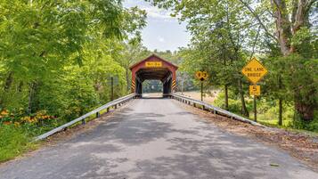 A covered bridge with a sign indicating a height limit of 9 feet 3 inches and a speed limit of 5 MPH.