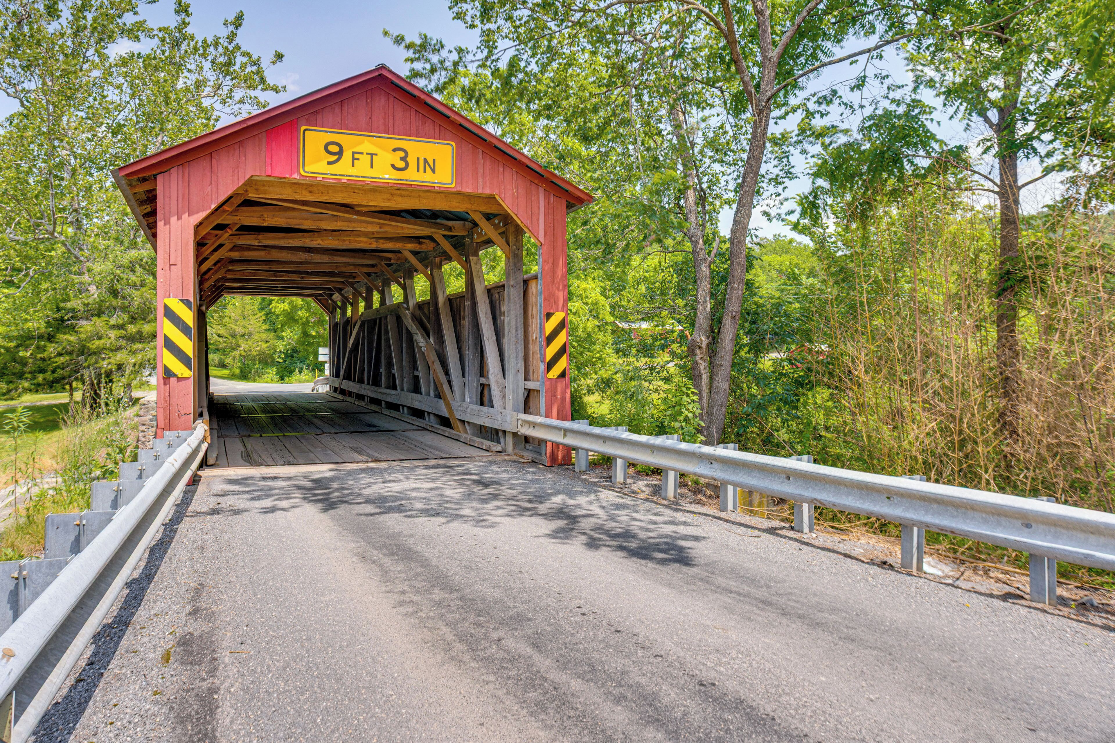 A covered bridge with a sign indicating a height restriction of 9 feet 3 inches.