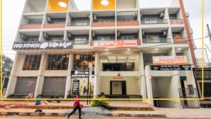 A multi-story building with various businesses including a fitness center, a salon, and a hotel. - Suraksha Stay Whitefield  (Bengaluru)