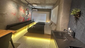 A modern interior with a seating area, a counter, and a wall-mounted plant. - US31 Yamanote Line a famous Japanese designer apartmentdirectly to Ueno2 minutes (荒川区)