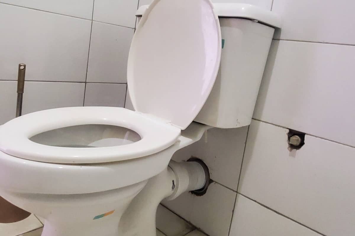 A white toilet with a closed seat in a tiled bathroom.