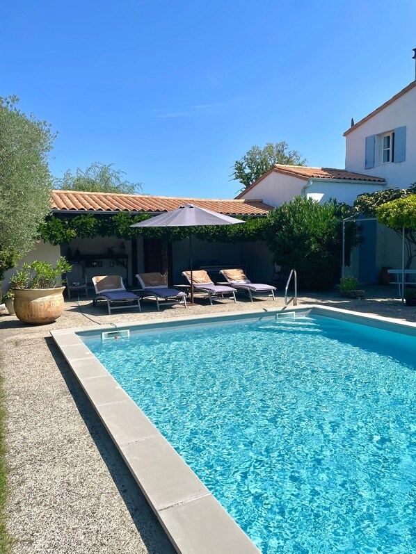 Ein Schwimmbad mit Liegestühlen und einer Pergola.