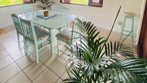 A dining area with a round table, chairs, and a large potted plant. - Fantastic villa Rodney Bay with epic views! Private pool, fab location 8 guests (Rodney Bay)