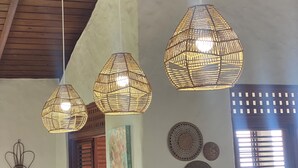 A room with a high ceiling, wooden beams, and three woven pendant lights. There are woven wall decorations and a window with blinds. - Fantastic villa Rodney Bay with epic views! Private pool, fab location 8 guests (Rodney Bay)