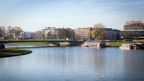 Un fiume con un ponte, imbarcazioni e edifici sullo sfondo.