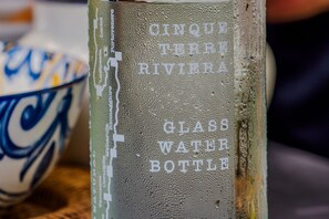 Une bouteille d’eau en verre avec du texte en relief.