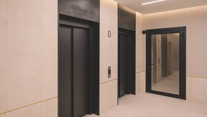 A modern hallway with two elevators, a mirrored door, and a light strip on the ceiling. - Rosa - Obud si w Sercu pi Knej Bydgoszczy (Bydgoszcz)