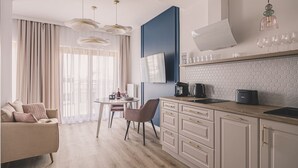 A modern kitchen with a dining area, featuring a wooden countertop, a coffee machine, and a dining table with chairs. - Rosa - Obud si w Sercu pi Knej Bydgoszczy (Bydgoszcz)