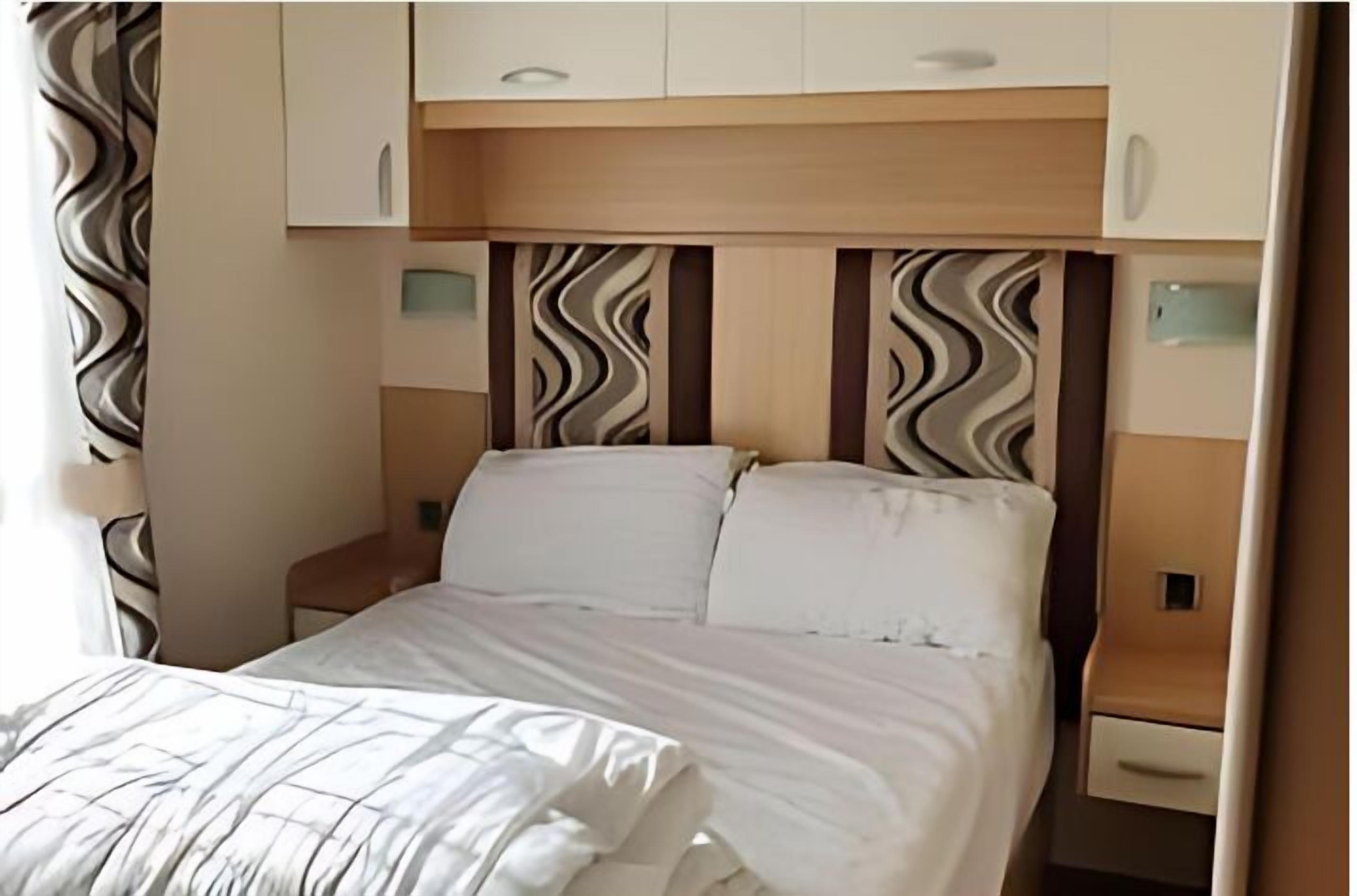 Ein Hotelzimmer mit einem Bett, einem Nachttisch und einem Kleiderschrank.