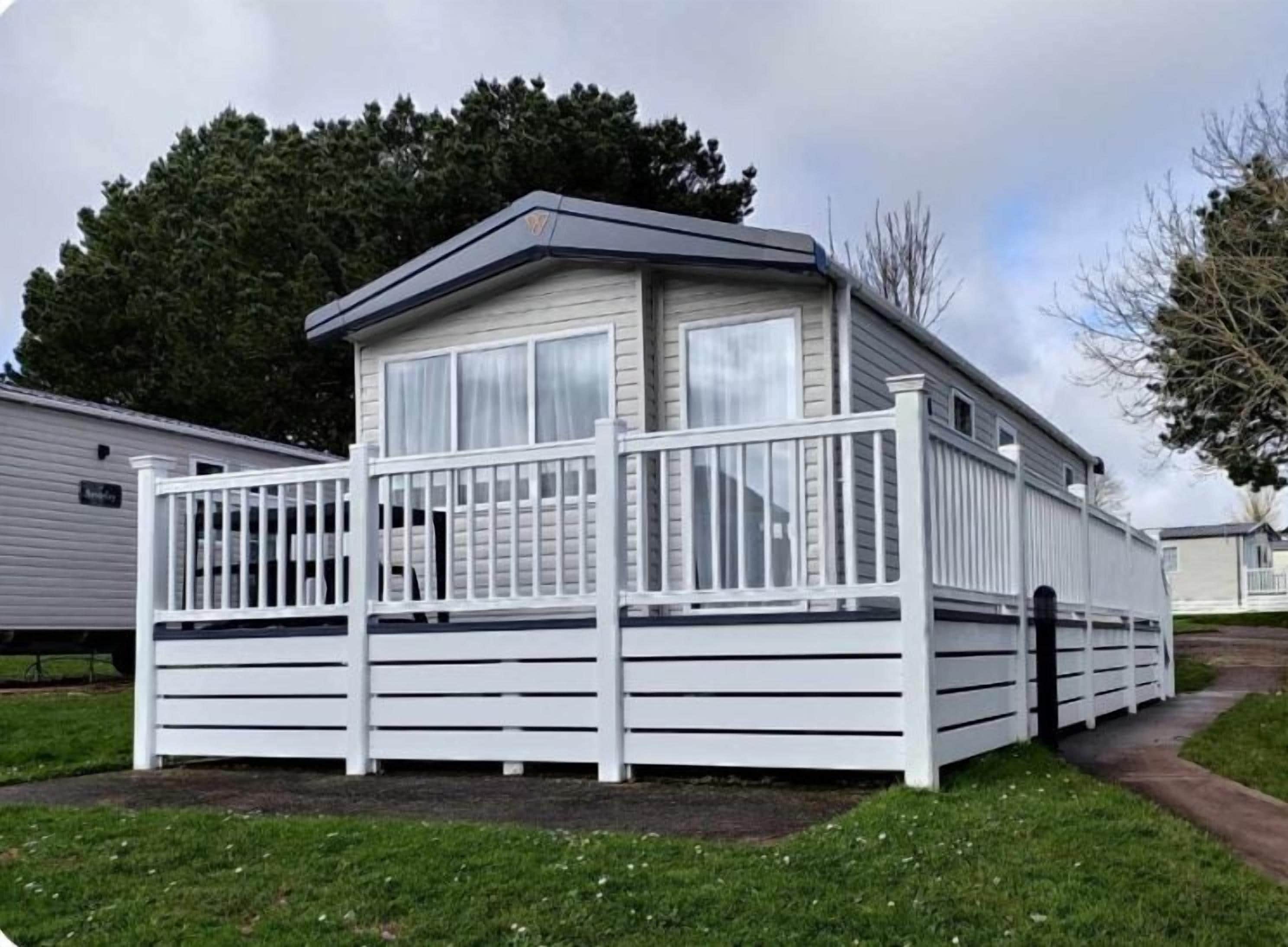 A mobile home with a fenced porch and a covered entryway.
