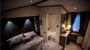 Un dormitorio con una cama grande, un escritorio y un baño.