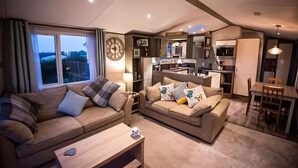 Un espacio habitable compacto con dos sofás, una mesa de comedor y una kitchenette.