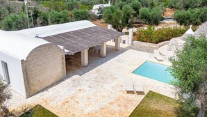 Une villa avec piscine, une terrasse en pierre et un jardin luxuriant.