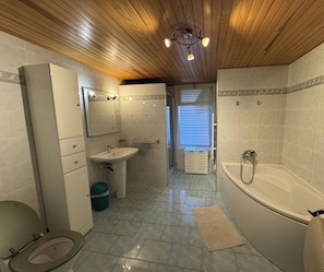 A bathroom with a toilet, sink, and bathtub.