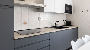 A modern kitchen with grey cabinets, a black sink, and a microwave. - Bologna Modern Apartment by Wonderful Italy (Bologna)