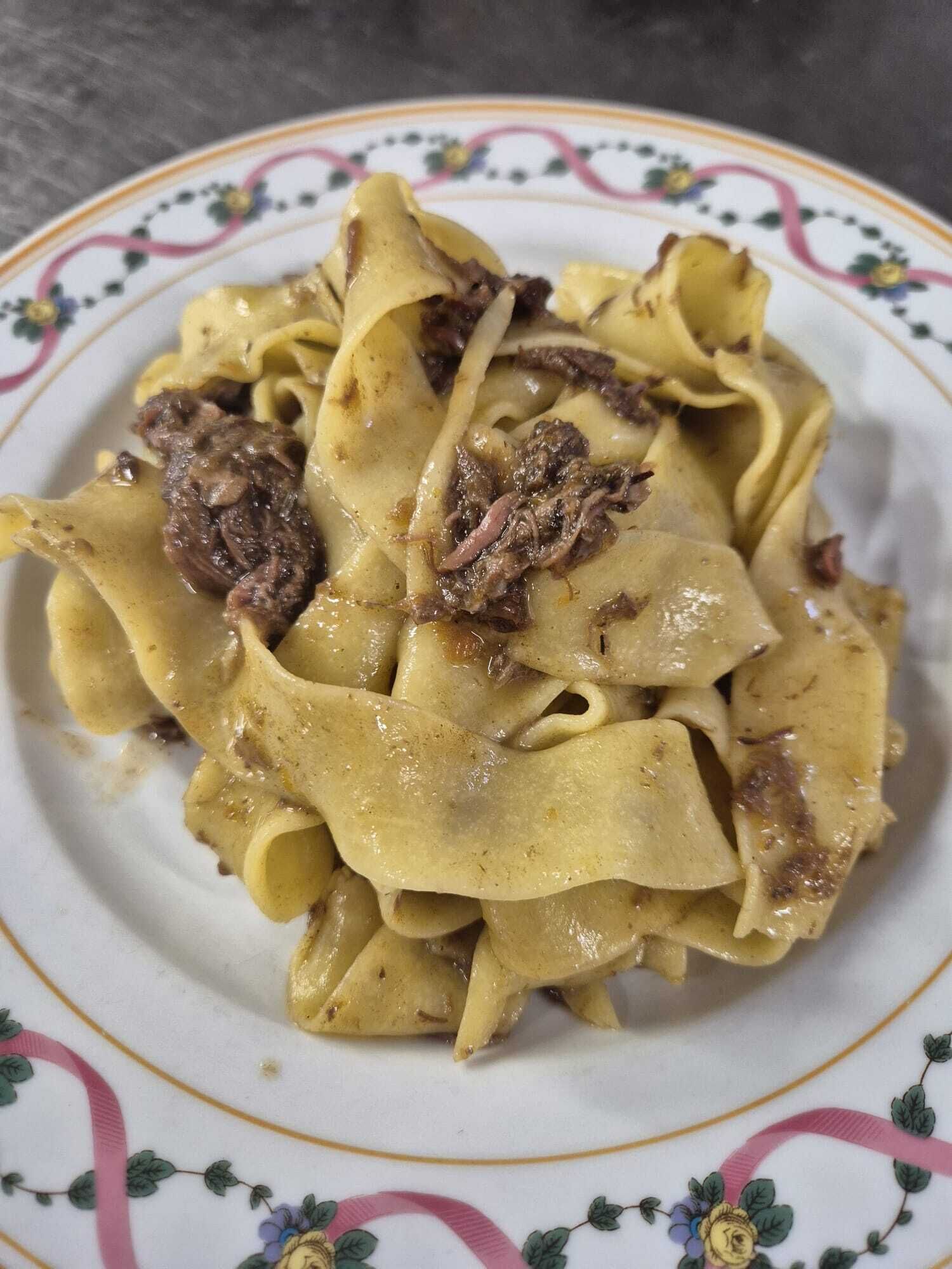 Un plato de pasta con salsa cremosa y trozos de carne.