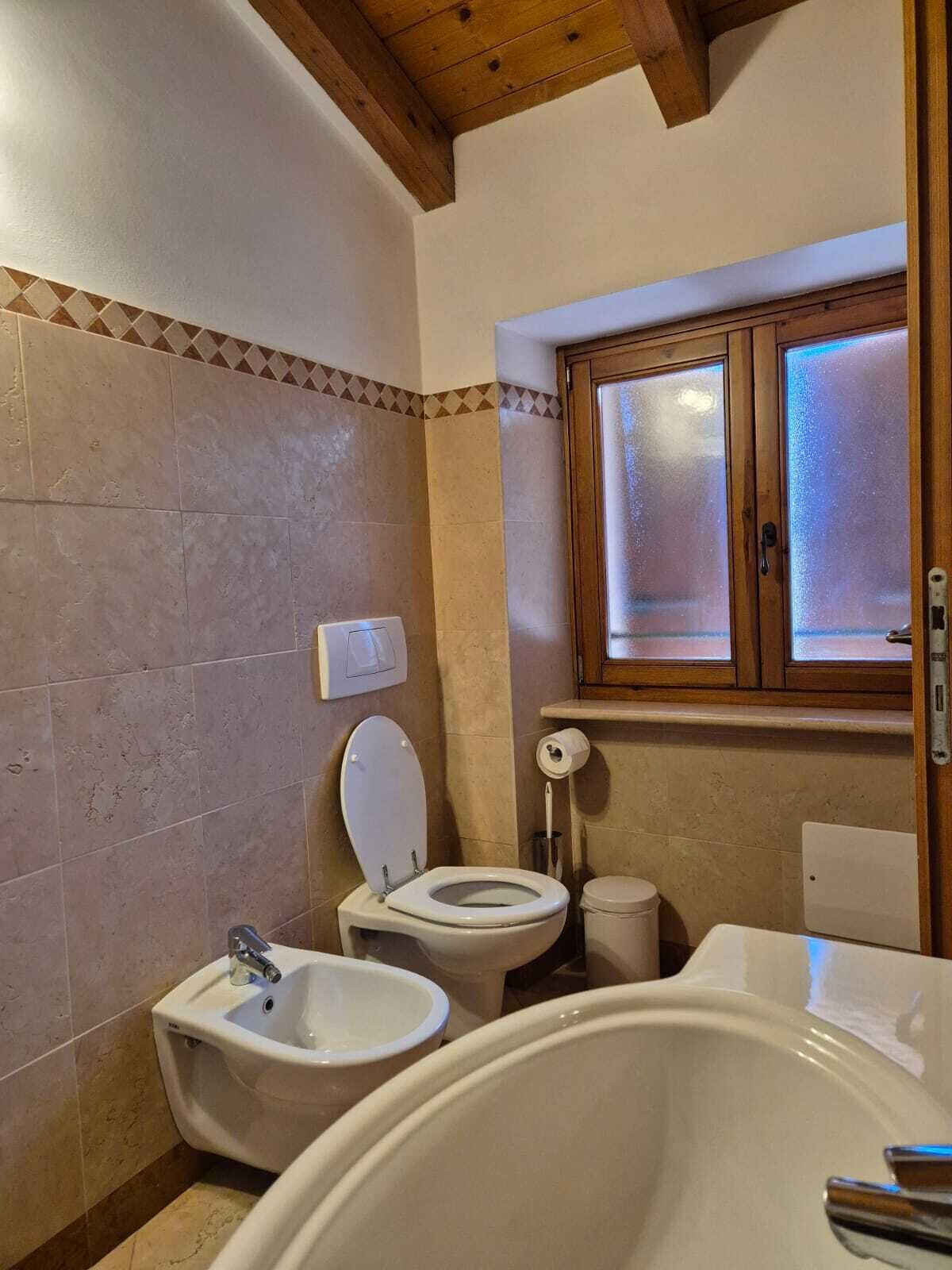 Ein Badezimmer mit zwei Toiletten, einem Bidet und einer Badewanne.