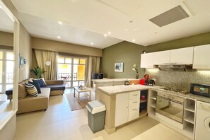 A modern kitchen with white cabinets, a built-in oven, and a granite countertop. - Xuru Stays I Minimal & Central 1bdr Apt. @ Abu Tig Marina (El Gouna)