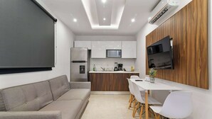 A modern kitchen with white cabinets, a microwave, and a built-in oven. - Stylish Studio in Zazil-Ha - Rooftop Pool (Playa del Carmen)