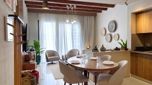 Un comedor moderno con una mesa redonda, sillas y una cocina al fondo.