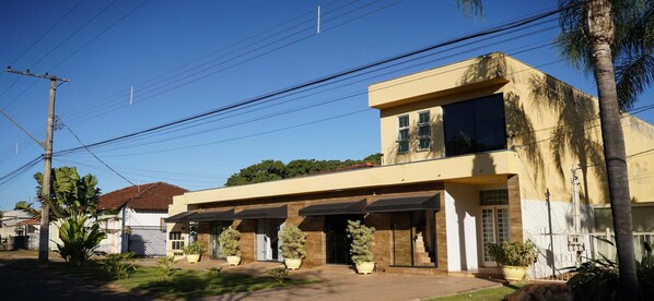 Una casa moderna de dos pisos con techo plano, ventanas amplias y un porche delantero cubierto.