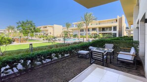 A modern outdoor patio with a pool view, outdoor seating, and a well-maintained garden. - Refreshed & Uplifted 2 BDR @ G Cribs (El Gouna)