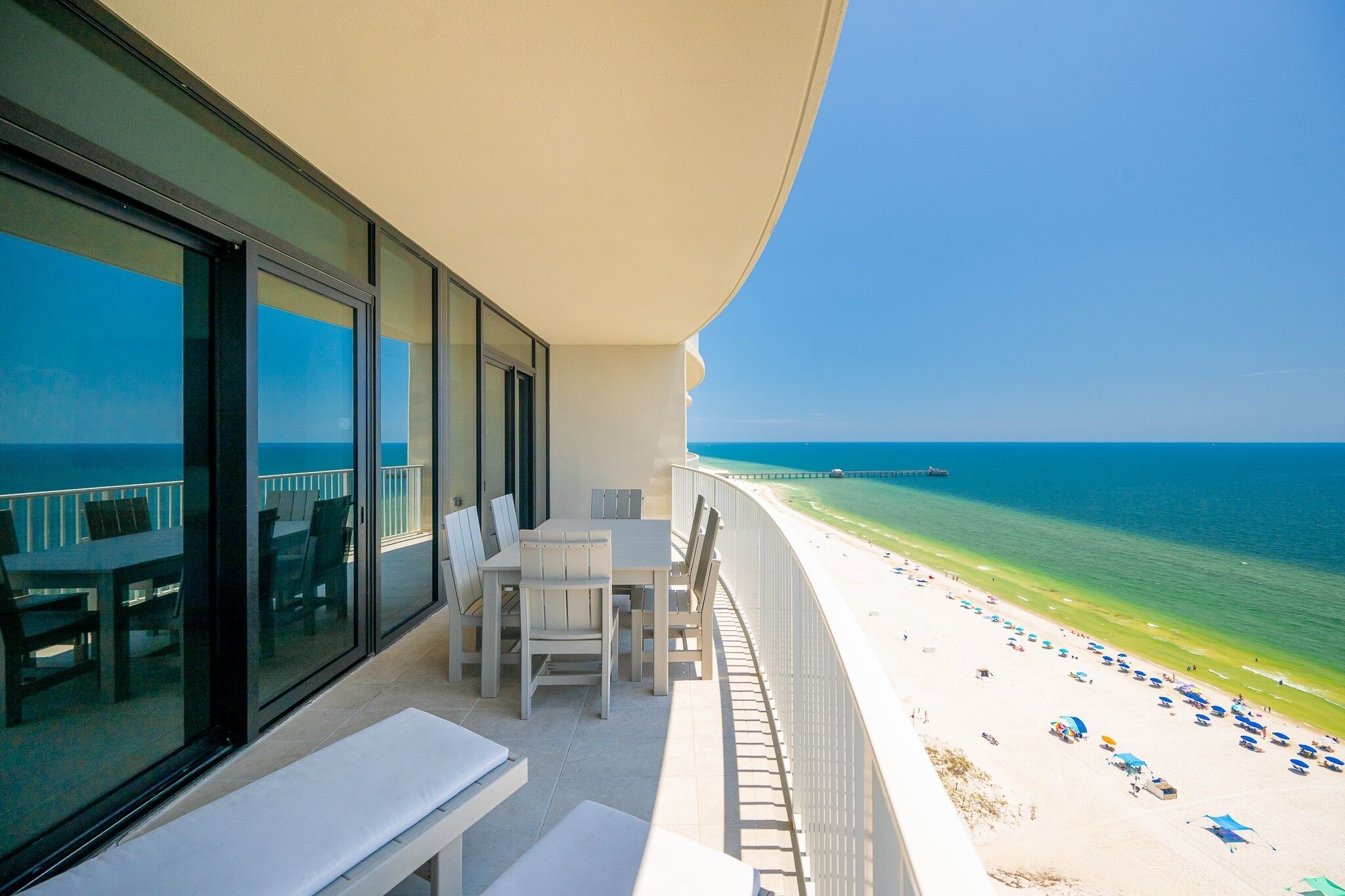 A balcony with a view of a beach and the ocean.