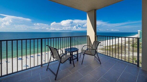 Ein Balkon mit Blick auf Strand und Meer.