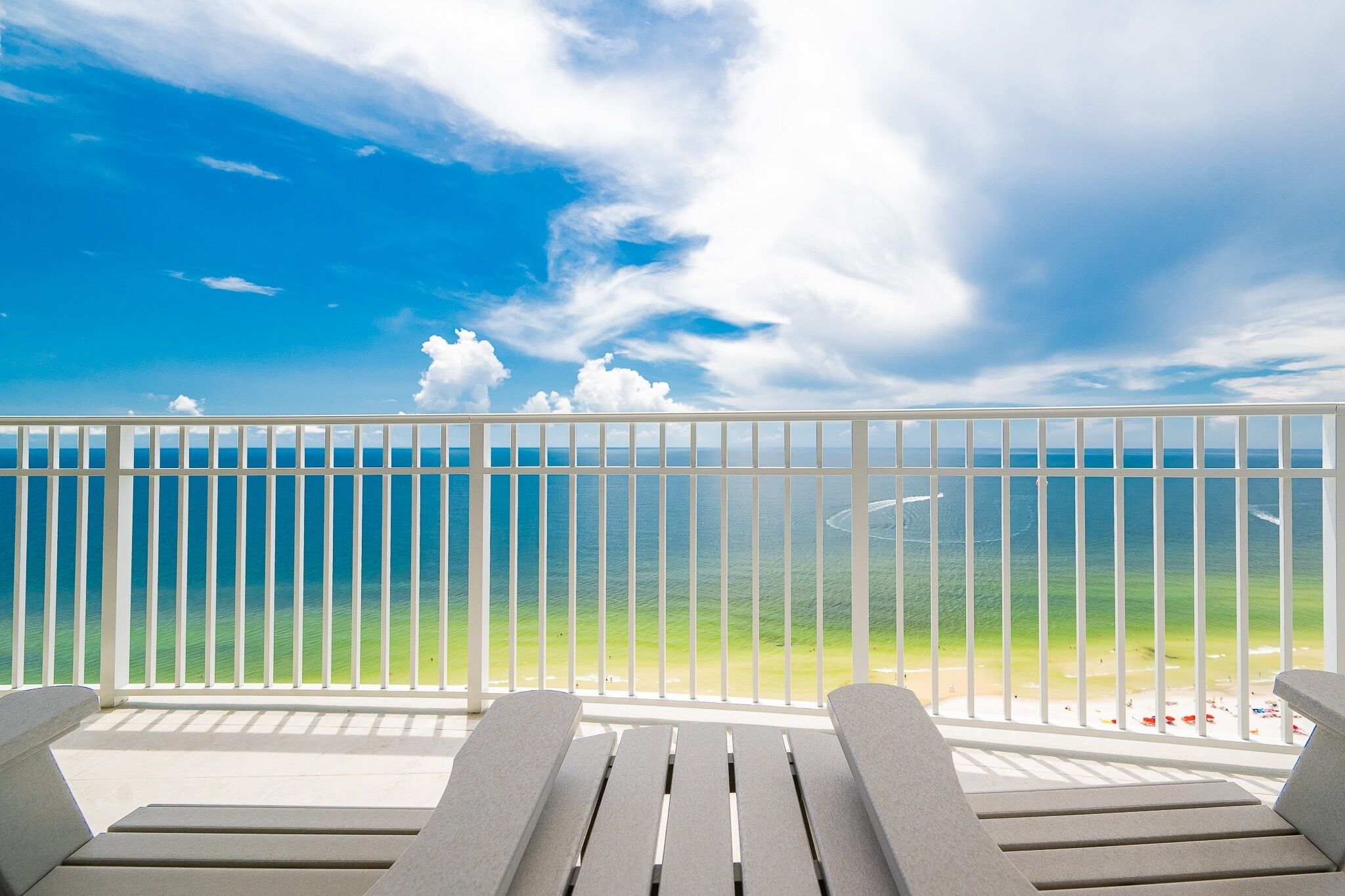 A balcony with a view of the ocean and beach.
