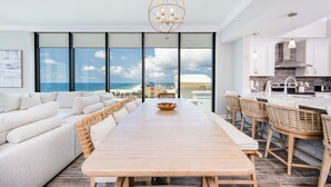 A modern kitchen with a large island, white cabinetry, and a view of the ocean. - Phoenix Gulf Shores Ii 2101 4 Bedroom Condo (Gulf Shores)