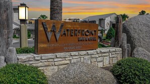 A sign for Waterfront Bar & Grill, indicating it is a private club for members and guests, located at 106 Cove West.