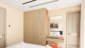 Une chambre d’hôtel avec un lit, un bureau, un miroir et une armoire.