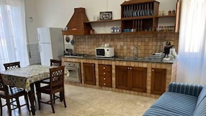 A compact kitchen with a microwave, oven, and wooden cabinets. - GranComfort between Naples and Caserta (Castel Volturno)