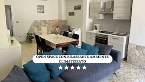 Una sala de estar moderna con un sofá, una mesa de comedor y una zona de cocina.