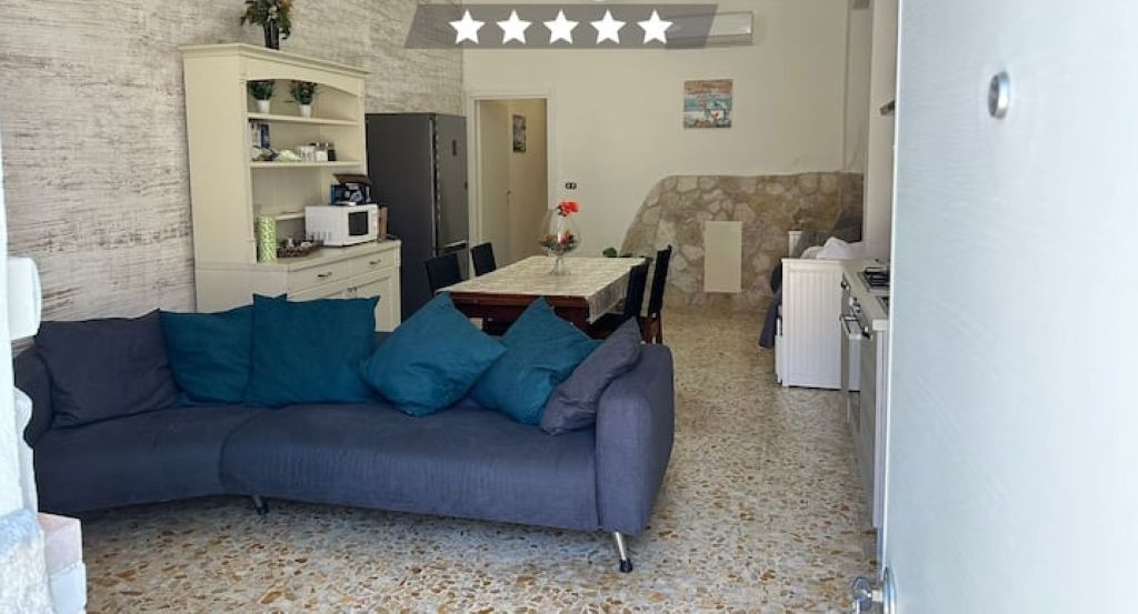 Un appartement confortable comprenant un coin repas, une kitchenette et un salon avec un canapé.