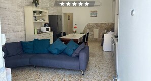 Ein gemütliches Apartment mit Essbereich, Küchenzeile und Wohnzimmer mit Sofa.