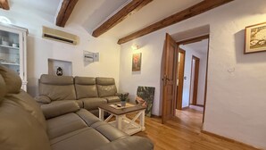 Ein Wohnzimmer mit einem Ecksofa, einem Couchtisch und einem Gemälde an der Wand.