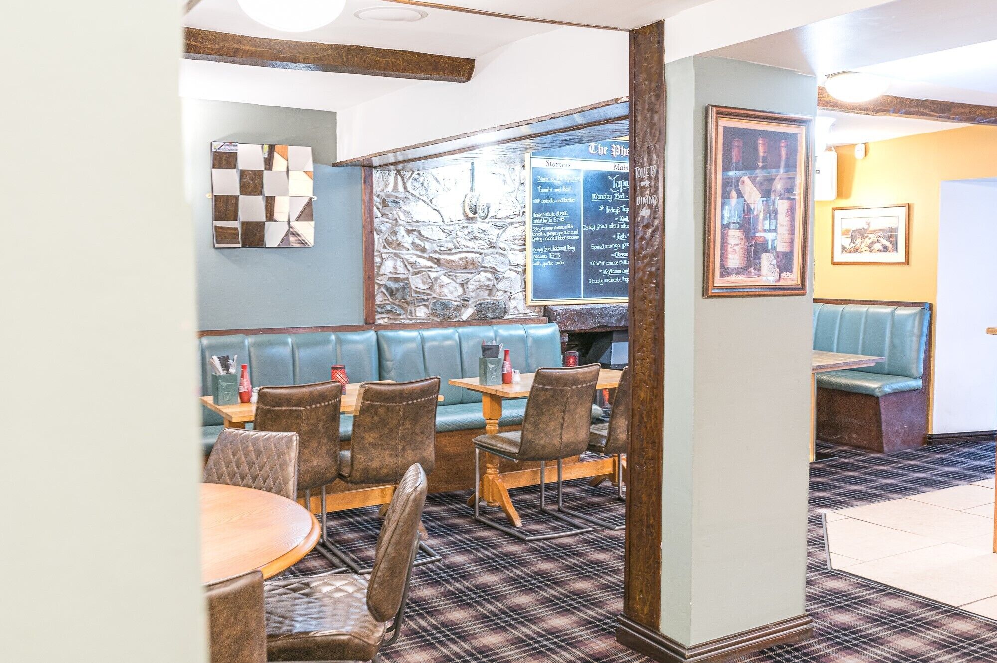 L'intérieur d'un restaurant, avec des banquettes, des tables et un panneau affichant le menu.