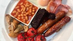 A plate with a variety of breakfast items including toast, eggs, beans, sausages, mushrooms, and tomatoes. - The Pheasant Inn (Grange-over-Sands)