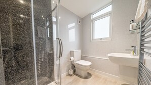 A modern bathroom with a shower, toilet, and sink. - The Pheasant Inn (Grange-over-Sands)