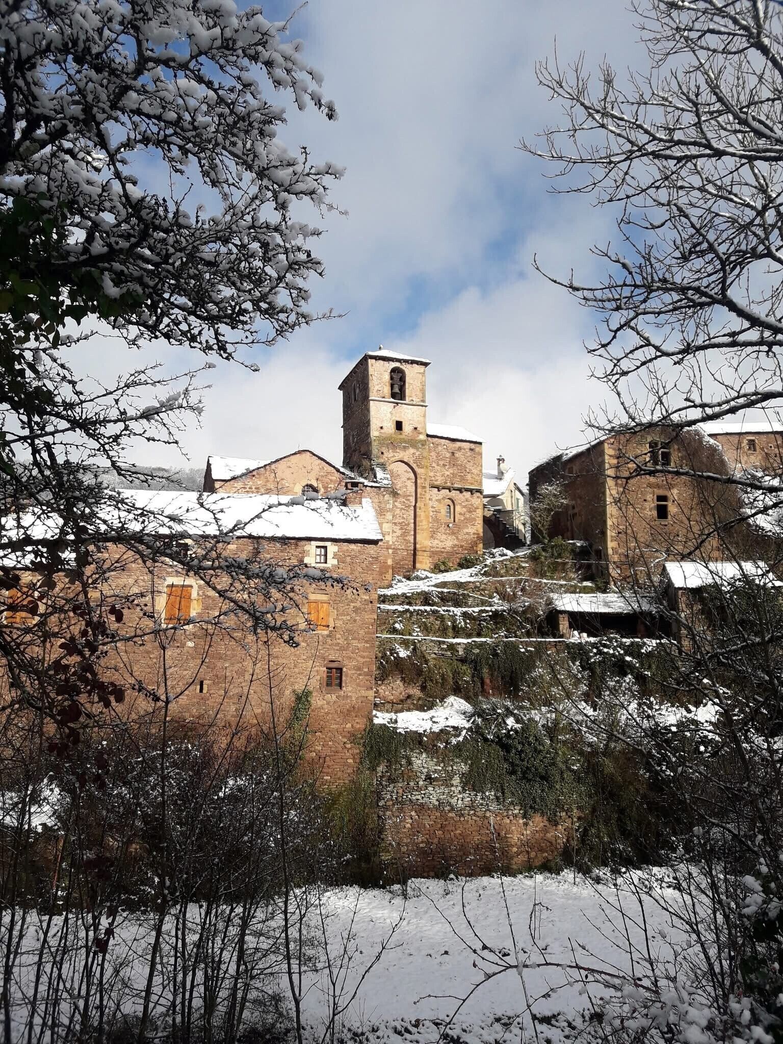 Une ville historique aux bâtiments enneigés et dont le clocher est un élément marquant du paysage.